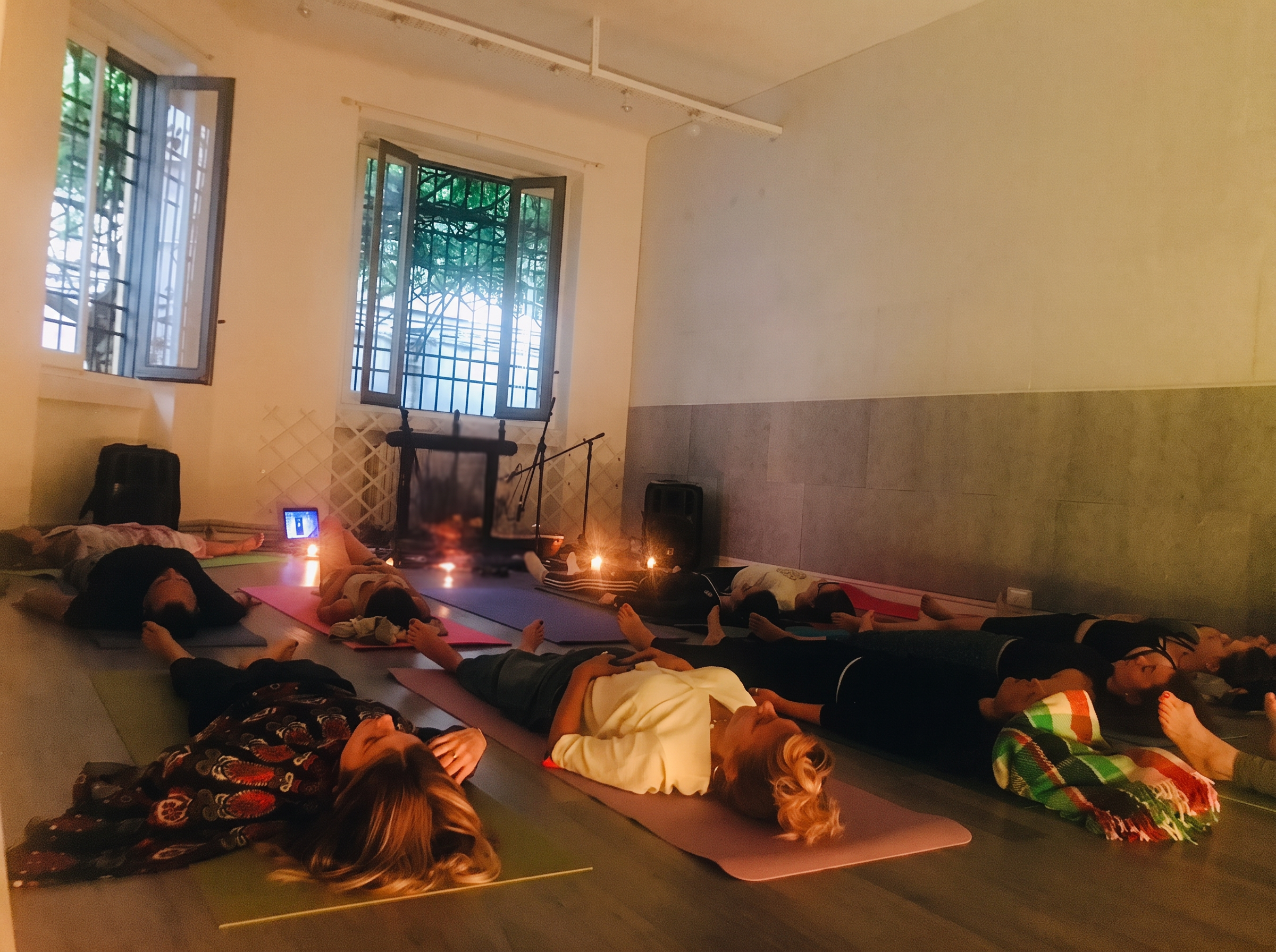 Rilassamento finale in savasana a lume di candela durante una sessione YogiSound